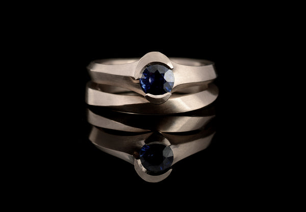 Carved sapphire and white gold engagement ring with mobius wedding band