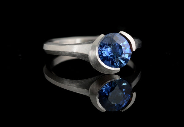 Carved platinum Arris ring with round blue sapphire