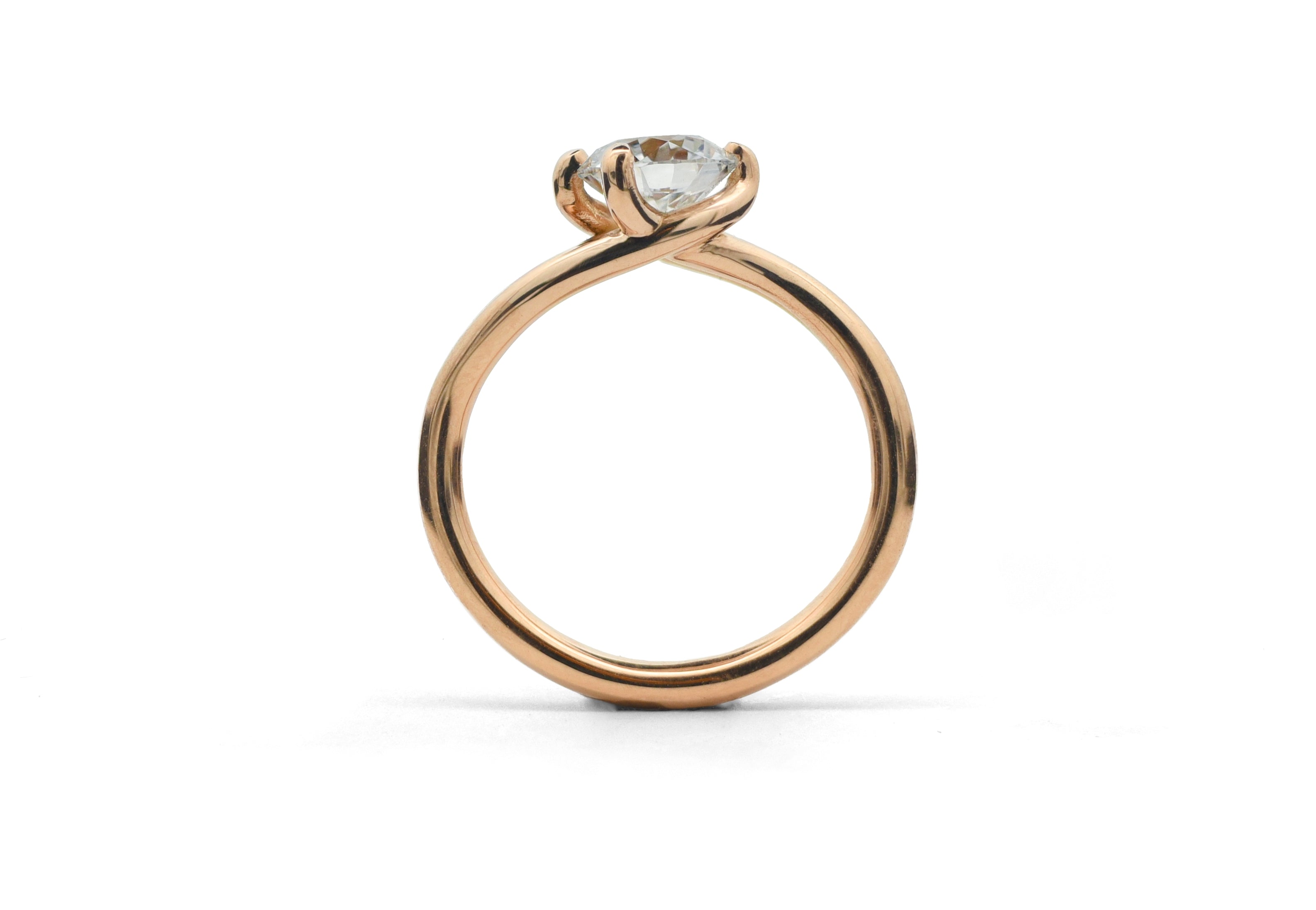 Rose gold Embrace ring with a diamond on a white background