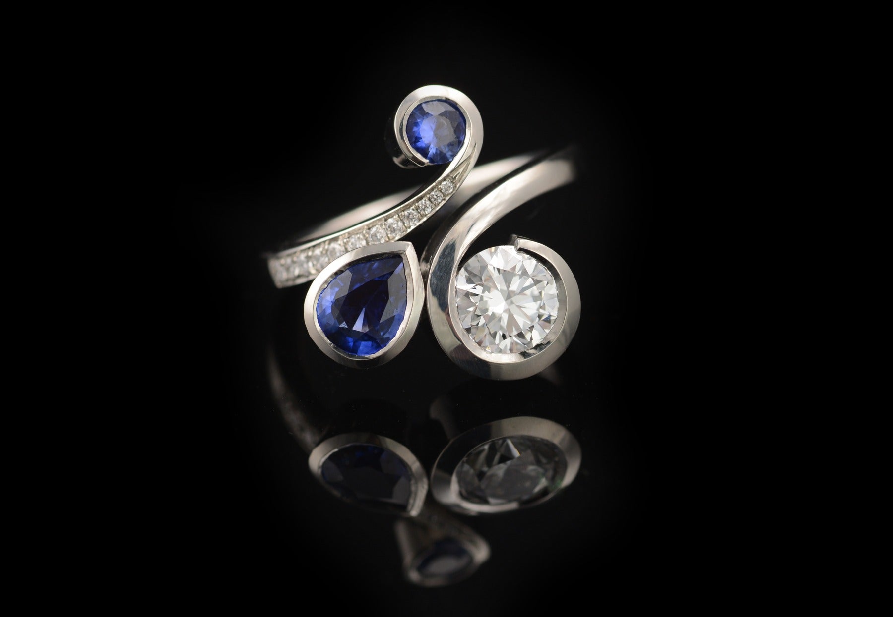 Twist pear and round blue sapphire and round white diamond platinum engagement ring