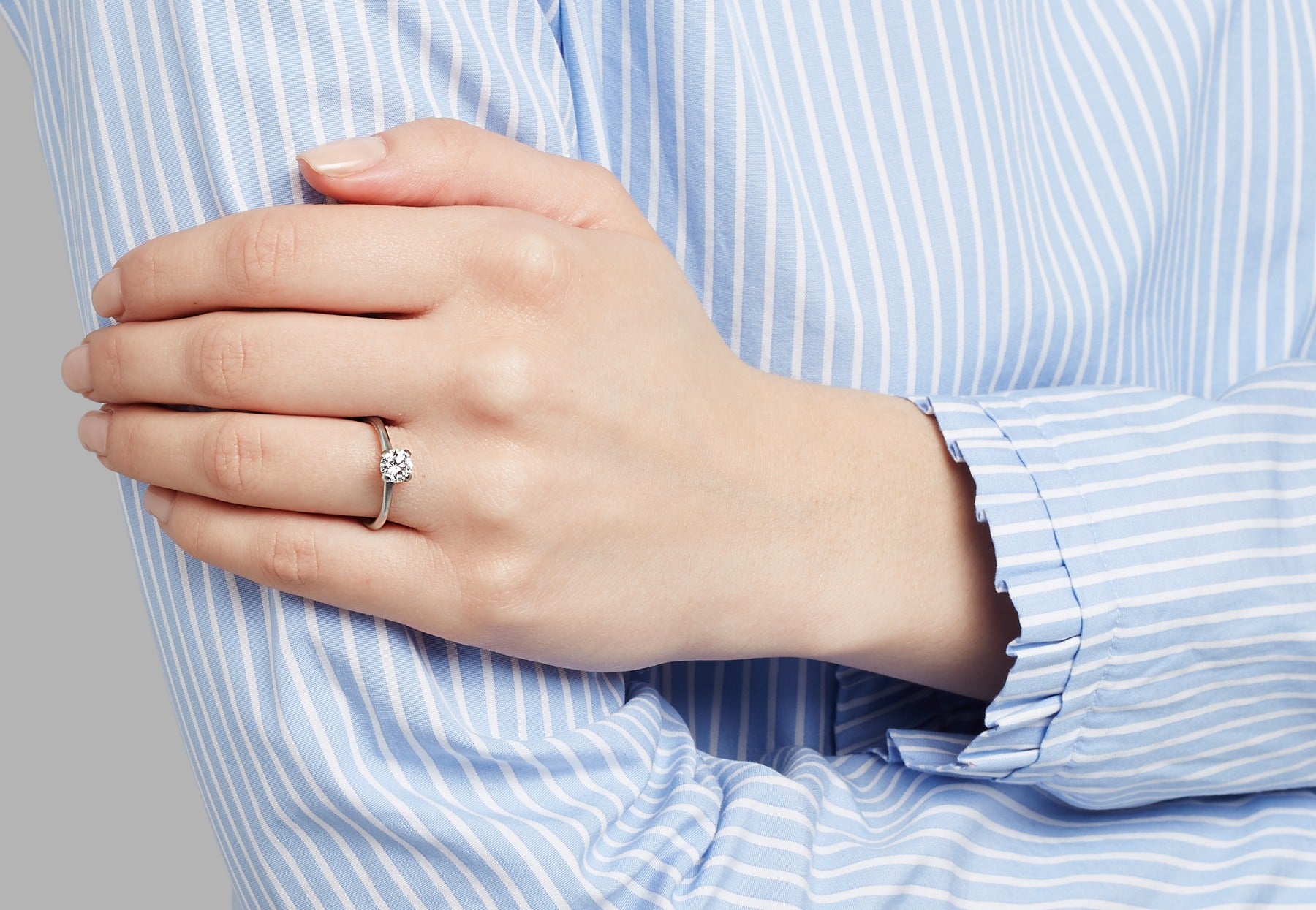 White diamond and platinum 4 claw engagement ring on hand