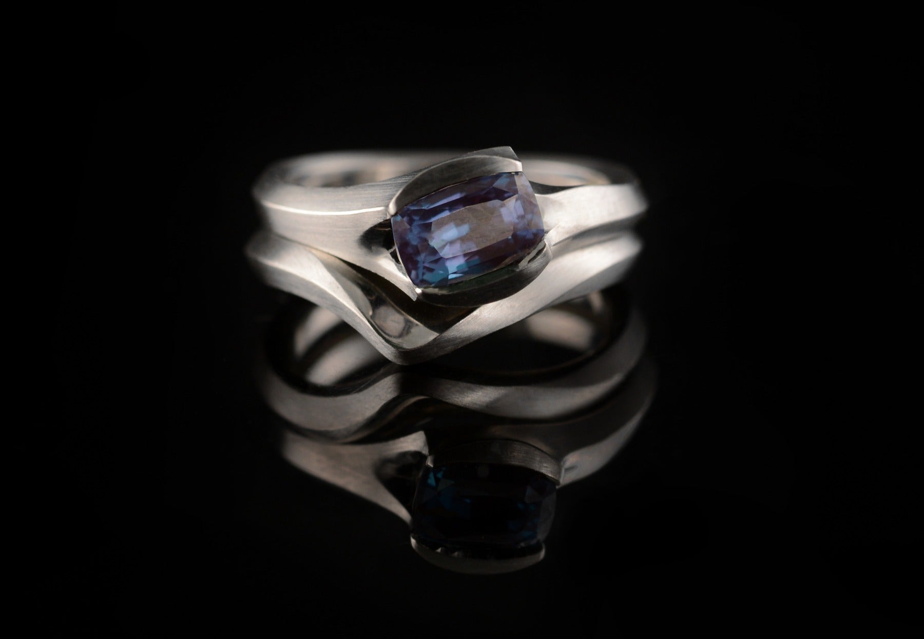 Carved alexandrite platinum engagement ring and fitted wedding ring