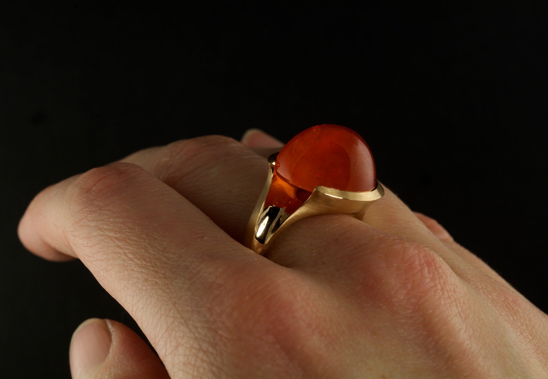 Carved garnet rose gold ring on hand