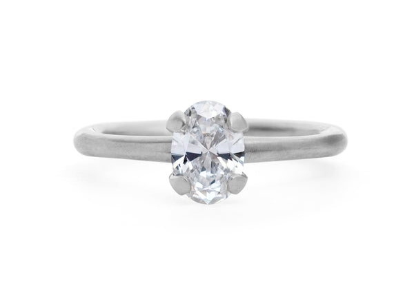 Oval white diamond and platinum sculpted four claw solitaire engagement ring