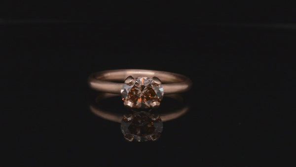 Rose gold four-claw engagement ring with oval cognac diamond