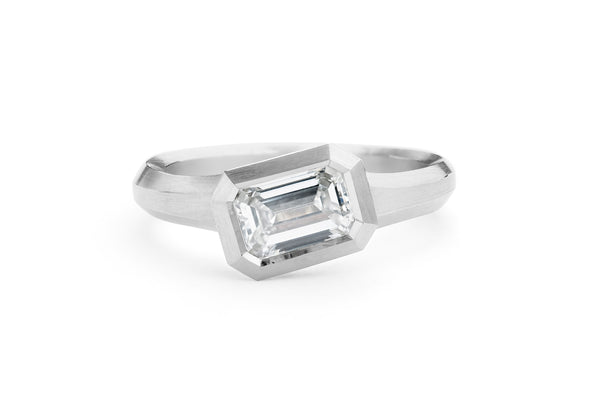 Arris carved platinum engagement ring with emerald-cut white diamond