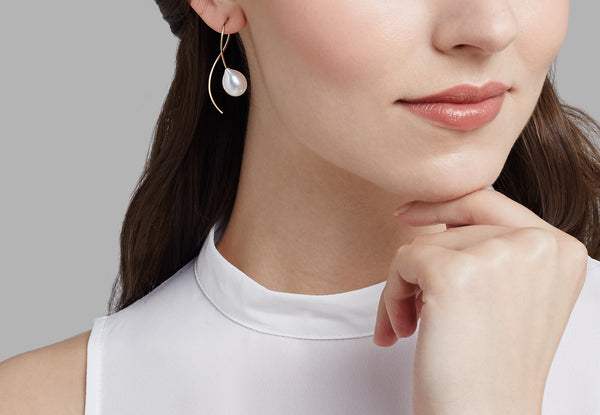 Contemporary white pearl drop earrings on model