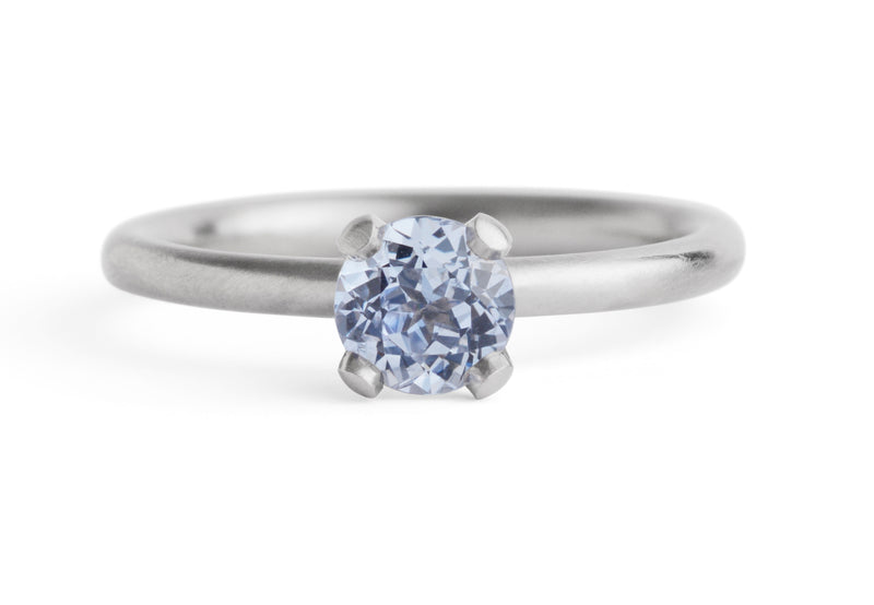 Fairtrade white gold sculpted four claw ring with sapphire