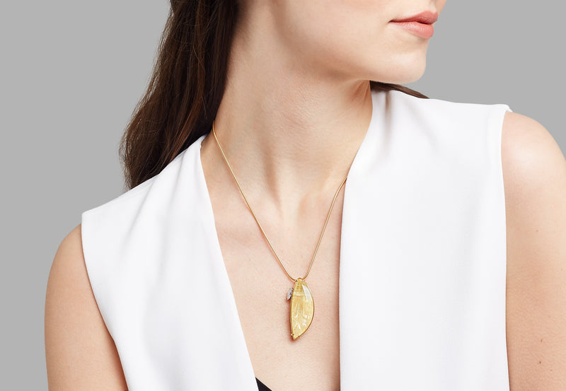 Gold, rutile quartz and diamond pendant worn by model